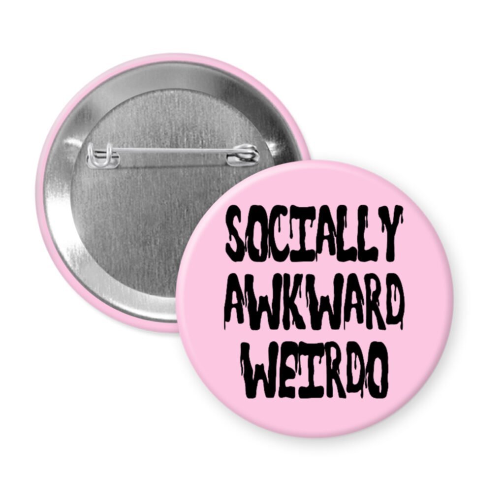 Pink pinback button with the text 'Socially awkward weirdo' printed in black drippy font.