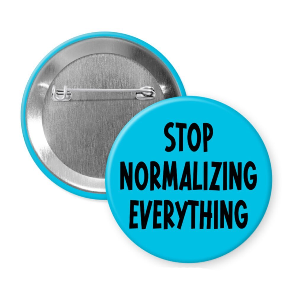 Blue pinback b utton with the text 'Stop normalizing everything' printed in black.