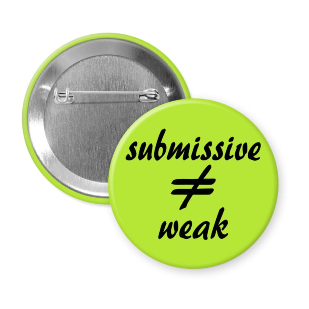 Green pinback button with the text 'submissive ≠ weak' printed in black.