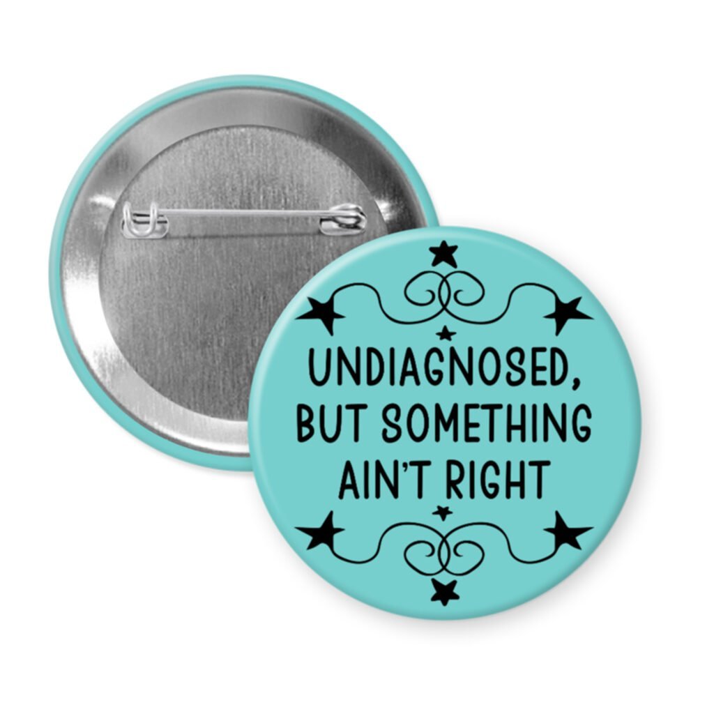 Blue pinback button with the text 'Undiagnosed, but something ain't right' printed in black.