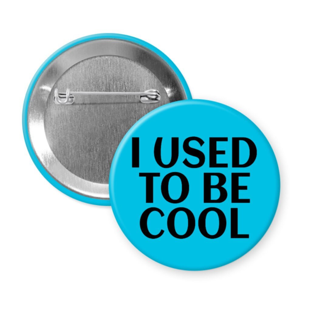 Blue pinback button with the text 'I USED TO BE COOL' printed in black.