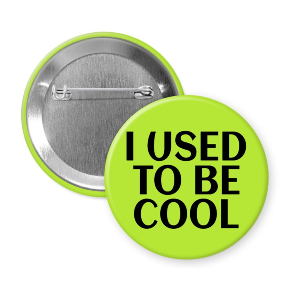 Green pinback button with the text 'I USED TO BE COOL' printed in black.