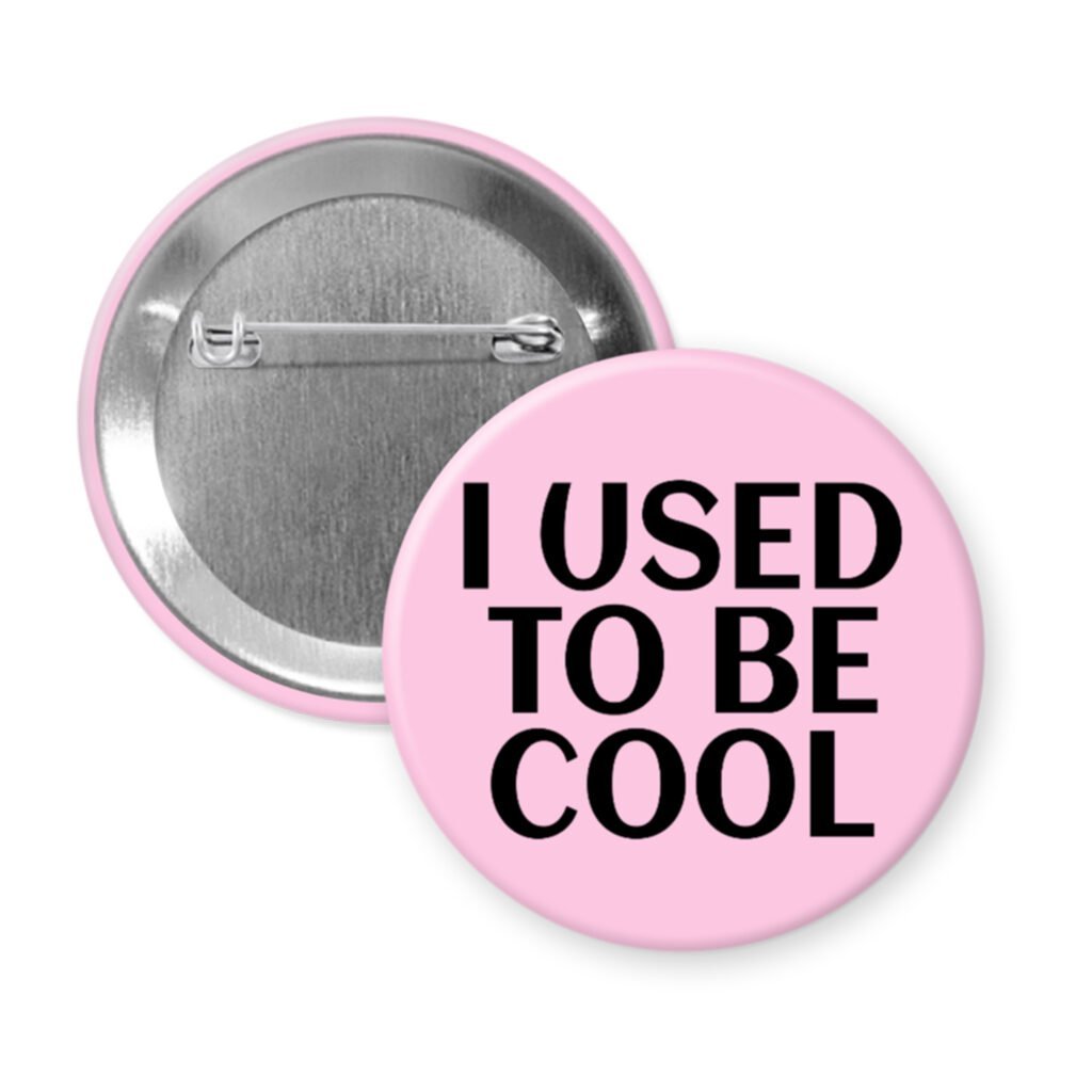 Pink pinback button with the text 'I USED TO BE COOL' printed in black.