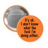 Orange pinback button with the text 'It's ok. I don't know what the fuck I'm doing either.' printed in black.