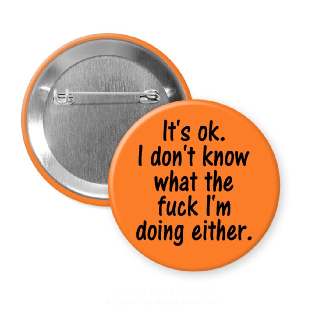 Orange pinback button with the text 'It's ok. I don't know what the fuck I'm doing either.' printed in black.