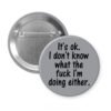 Grey pinback button with the text 'It's ok. I don't know what the fuck I'm doing either.' printed in black.