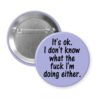 Purple pinback button with the text 'It's ok. I don't know what the fuck I'm doing either.' printed in black.