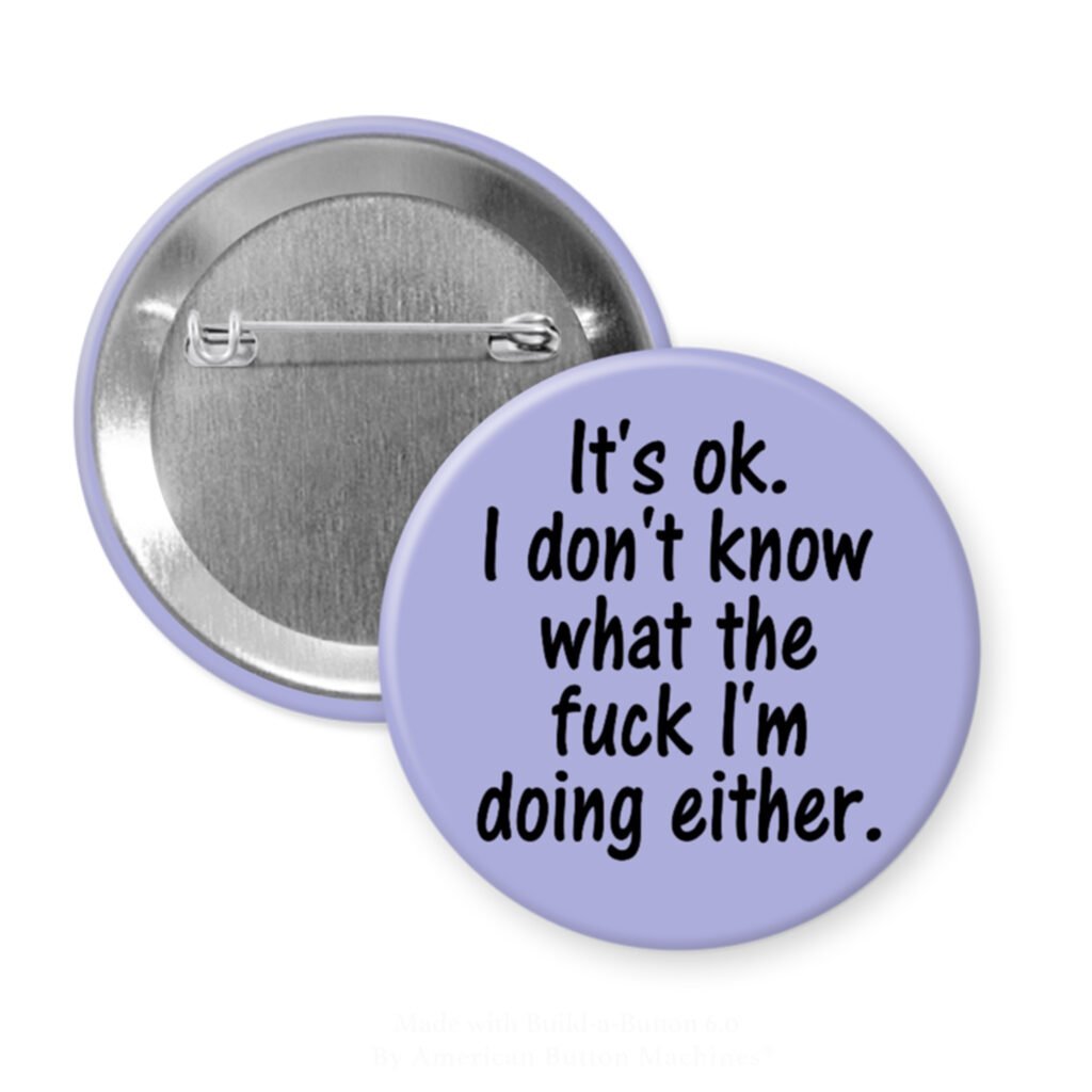 Purple pinback button with the text 'It's ok. I don't know what the fuck I'm doing either.' printed in black.