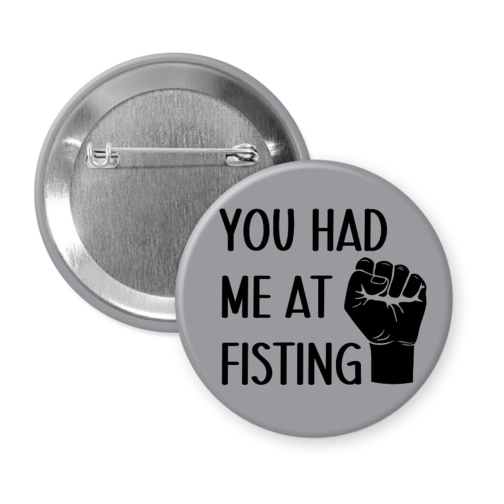 Grey pinback button with an image of a fist and the text 'You had me at fisting'.