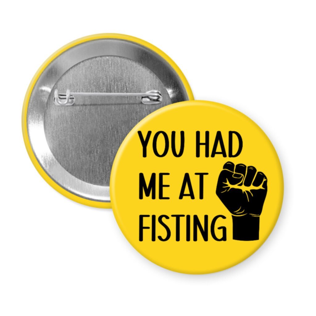 Yellow pinback button with an image of a fist and the text 'You had me at fisting'.