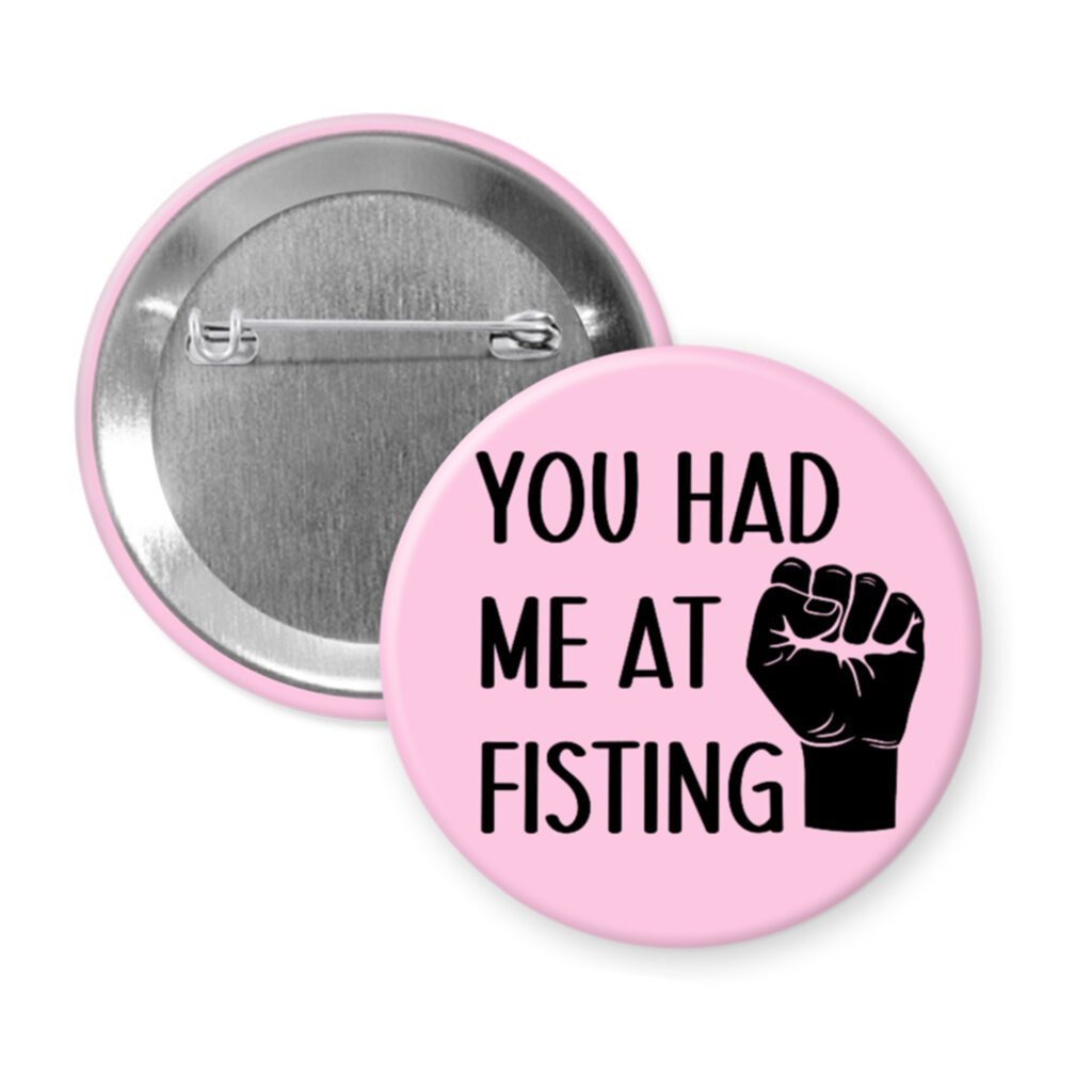 Pink pinback button with an image of a fist and the text 'You had me at fisting'.