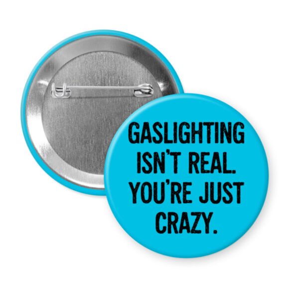 Blue button pin with the text 'Gaslighting isn't real. You're just crazy' in black distressed text.