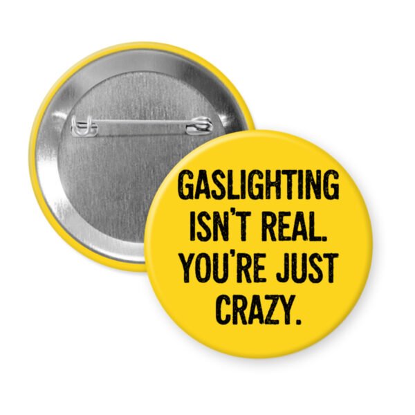 Yellow button pin with the text 'Gaslighting isn't real. You're just crazy' in black distressed text.