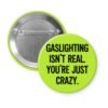 Green button pin with the text 'Gaslighting isn't real. You're just crazy' in black distressed text.