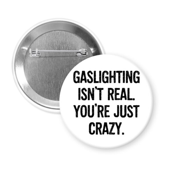 White button pin with the text 'Gaslighting isn't real. You're just crazy' in black distressed text.
