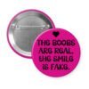 Hot pink button with the text 'The boobs are real, the smile is fake'.