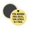 Yellow magnet with the text 'The boobs are real, the smile is fake'.