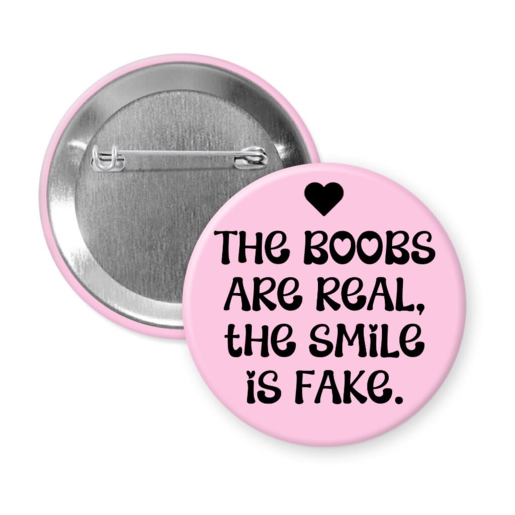 Pink button with the text 'The boobs are real, the smile is fake'.