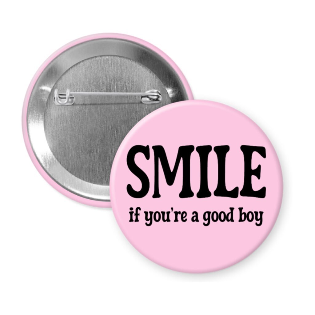 Pink button with the text 'SMILE if you're a good boy' printed in black.