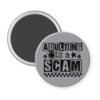 Grey magnet with bold black text reading ‘Adulting is a Scam’ in mixed block and distressed fonts. The design includes a smiley face, star, and flower icons, with a checkerboard stripe along the bottom.