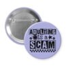 Purple pinback button with bold black text reading ‘Adulting is a Scam’ in mixed block and distressed fonts. The design includes a smiley face, star, and flower icons, with a checkerboard stripe along the bottom.