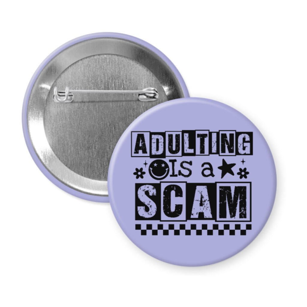 Purple pinback button with bold black text reading ‘Adulting is a Scam’ in mixed block and distressed fonts. The design includes a smiley face, star, and flower icons, with a checkerboard stripe along the bottom.