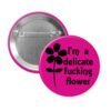 Fuchsia pink pinback button with image of a flower and the text 'I'm a delicate fucking flower' printed in black.