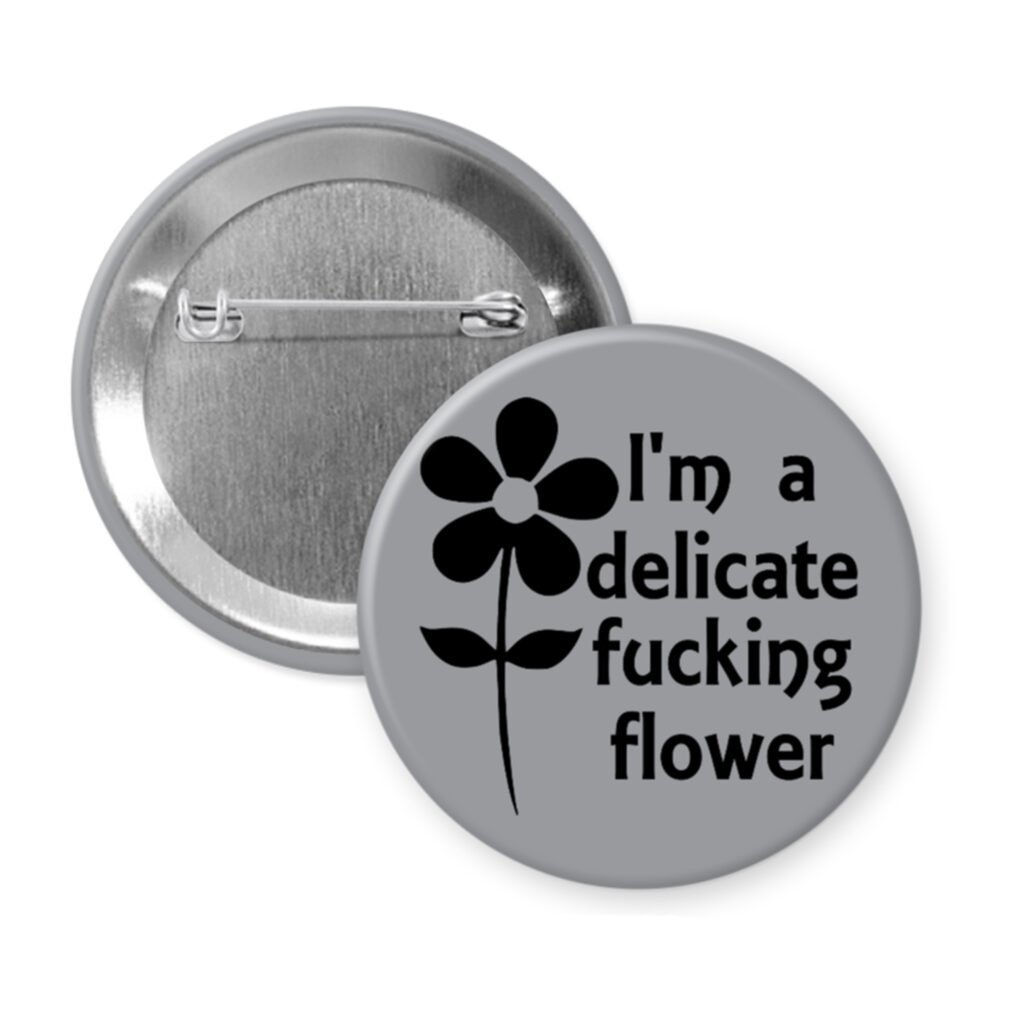 Grey pinback button with image of a flower and the text 'I'm a delicate fucking flower' printed in black.