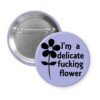 Purple pinback button with image of a flower and the text 'I'm a delicate fucking flower' printed in black.