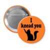 Orange pinback button with silhouette of a cat and the text 'I knead you.'