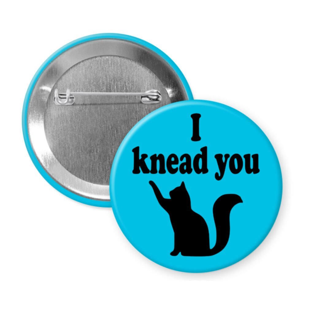 Blue pinback button with silhouette of a cat and the text 'I knead you.'