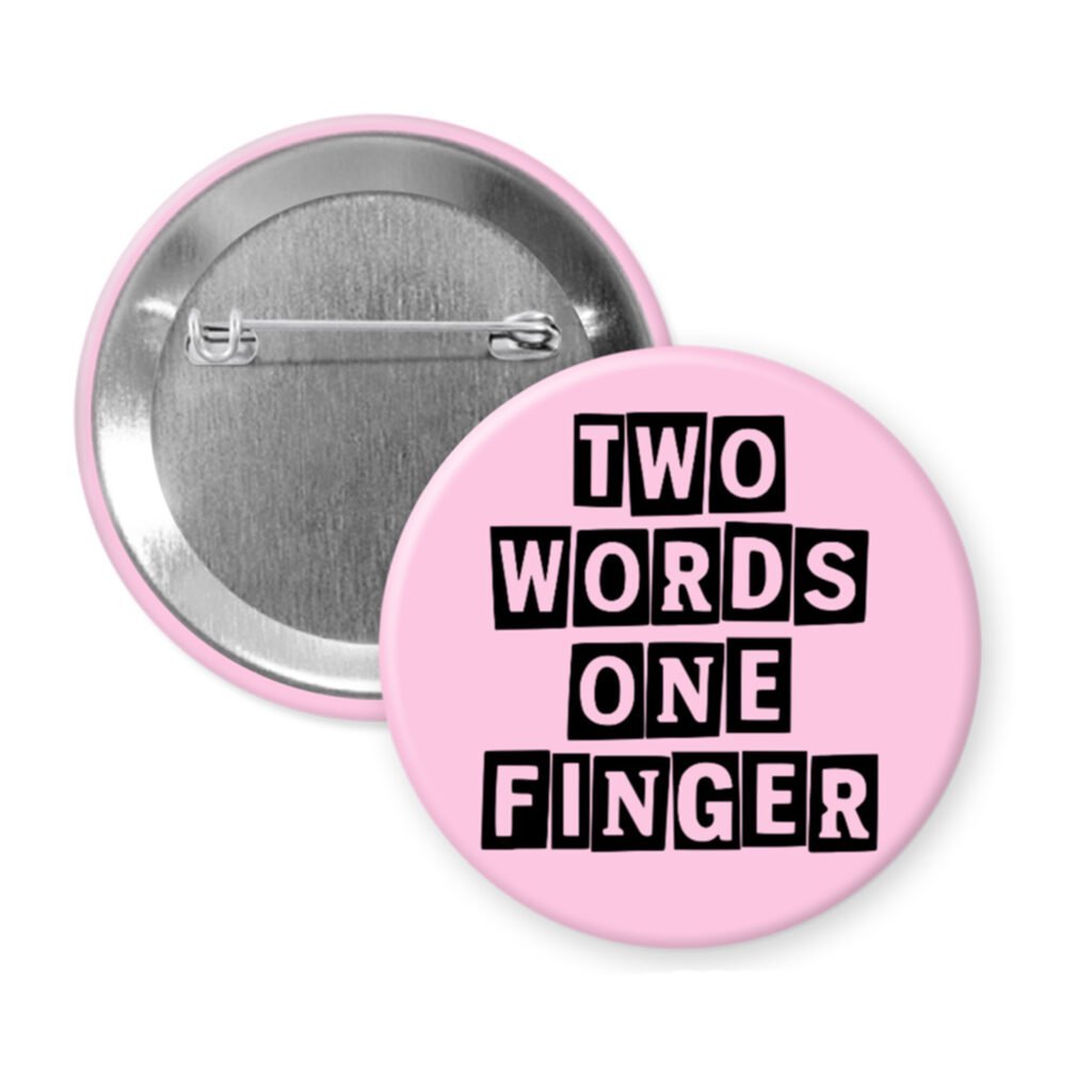 Pink pinback button with the text 'TWO WORDS ONE FINGER' printed in black stencil font.