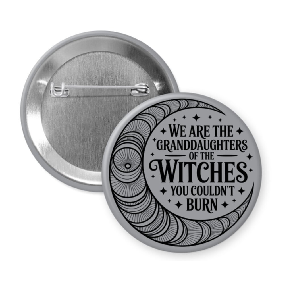 Grey pinback button with image of a line art moon and the text 'We are the granddaughters of the witches you couldn't burn' printed in black.