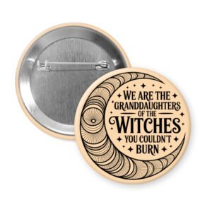 Peach color pinback button with image of a line art moon and the text 'We are the granddaughters of the witches you couldn't burn' printed in black.