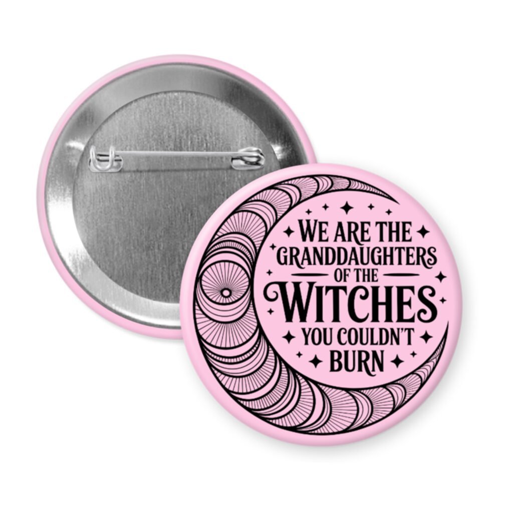 Light pink pinback button with image of a line art moon and the text 'We are the granddaughters of the witches you couldn't burn' printed in black.