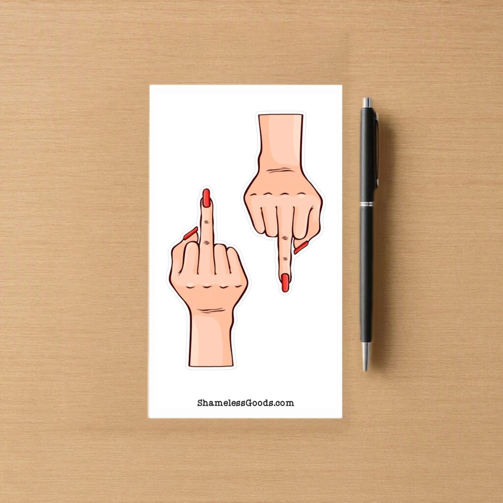 Sticker sheet with two light‑skin hand designs showing middle‑finger gesture and red nails, placed beside a pen on wood surface.