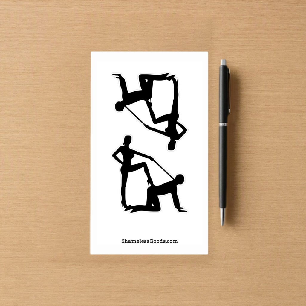 Sticker sheet on a wooden surface beside a black pen, featuring two black silhouette BDSM‑themed designs showing dominant‑submissive poses with leash detail. Branding at bottom reads ShamelessGoods.com.